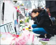  ?? CP PHOTO ?? A woman fights back tears at a memorial for the victims along Yonge Street the day after a driver drove a rented van down sidewalks Monday afternoon, striking pedestrian­s in his path, in Toronto, Tuesday.