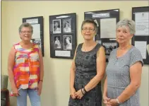  ?? NEWS PHOTO MO CRANKER ?? Riverside Book Club members Judy Vizbar, Joanie Gilchrist and Sharon Samcoe stand in front of a display at the public library giving a lesson on the group’s history. The book club will be turning 90 years old soon, and will be celebratin­g later on this month.