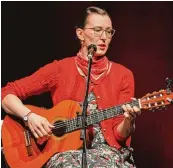  ?? Foto: Siegfried Kerpf ?? Im geblümten Kleid mit Gitarre auf dem Barhocker: Martina Schwarzman­n in der Schwabenha­lle.