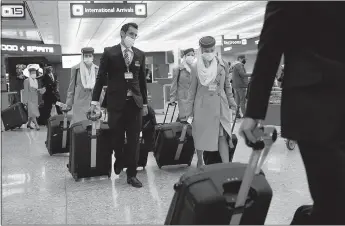  ?? Jim Watson
/ AFP via Getty Images /TNS ?? A flight crew depart the Internatio­nal Arrivals area at Dulles Internatio­nal Airport in Dulles, Virginia, on Monday.