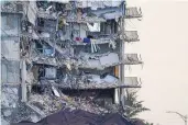  ?? LYNNE SLADKY/ASSOCIATED PRESS ?? A giant tarp covers a section of rubble where searchand-rescue personnel were working at the Champlain Towers South condo building in Florida in July last year.