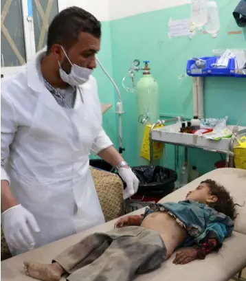  ??  ?? HORRIFYING IMAGES OF WAR: A doctor and a child victim of an air strike on the outskirts of Saada, Yemen, last week. Photo: Naif Rahma/Reuters