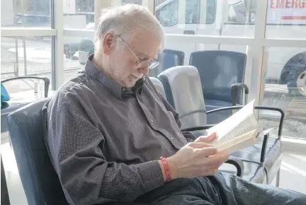  ??  ?? Patient John Chaffey, 68, brought a book with him as he awaited medical care in the waiting room at the Queensway Carleton Hospital.