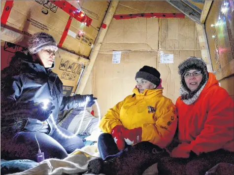  ?? COLIN CHISHOLM ?? From left, Jennifer Dill, Donna Eldridge, and Kathy Riley try to stay warm inside a makeshift tent. They spend the night inside it each year to bring attention and awareness of the plight of homeless and displaced people.