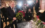  ??  ?? Russian President Vladimir Putin lays flowers near the subway station in St. Petersburg, Russia, where a bomb killed several people. See story on A2 and go to theday.com for a gallery of the day’s best wire photos.