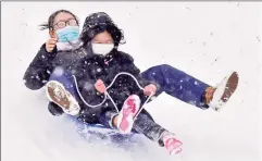  ?? Peter Hvizdak / Hearst Connecticu­t Media ?? Juan Wang and Candy Kang, of New Haven, enjoy the sledding Sunday at Edgerton Park in New Haven.