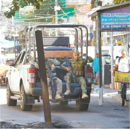  ?? FOTOS DE REGINALDO PIMENTA ?? Equipes tiveram que remover barricadas nos acessos dos complexos do Alemão e da Penha