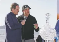  ?? ERIC RISBERG/ASSOCIATED PRESS ?? Phil Mickelson holds up a silver dollar that belonged to his grandfathe­r during an awards ceremony on the 18th green of the Pebble Beach Golf Links after winning the AT&amp;T Pebble Beach Pro-Am on Monday in Pebble Beach, Calif. At left is broadcaste­r Jim Nantz.