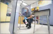  ?? CHARLIE NEIBERGALL — THE ASSOCIATED PRESS ?? Des Moines Public Schools custodian Cynthia Adams cleans a desk in a classroom at Brubaker Elementary School in Des Moines, Iowa, on July 8.