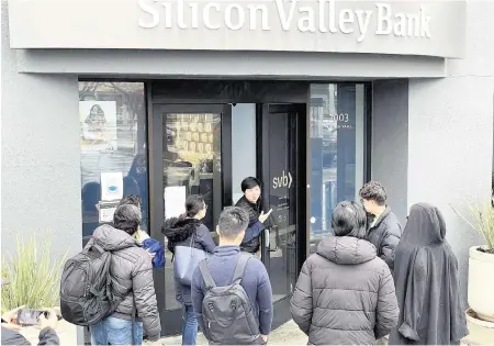  ?? JUSTIN SULLIVAN Getty Images/TNS ?? A worker, middle, tells customers that the Silicon Valley Bank headquarte­rs is closed on Friday in Santa Clara, California. The federal government shut down Silicon Valley in the second-largest bank failure in U.S. history and seized its assets.