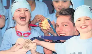  ??  ?? Champion The children try on Duncan’s world championsh­ip medal