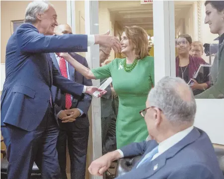  ?? AP PHOTO ?? ‘CRITICAL’: Sen. Edward J. Markey (D-Mass.), left, hugs House Minority Leader Nancy Pelosi, center, after the Senate passed a resolution yesterday to reverse the FCC decision to end net neutrality, a decision widely protested, below.