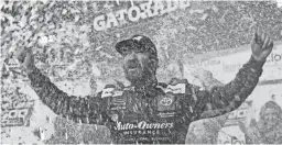  ??  ?? Martin Truex Jr. celebrates Sunday after winning the NASCAR Cup Series race at Martinsvil­le Speedway. Truex led 464 of the 500 laps on the way to his first victory at the track.