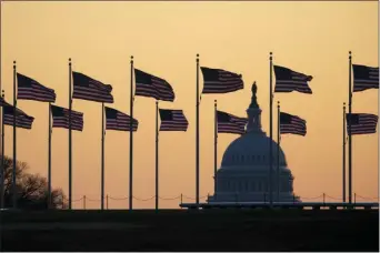  ?? JON ELSWICK — THE ASSOCIATED PRESS ?? American flags blow in wind around the Washington Monument with the U.S. Capitol in the background at sunrise on Monday in Washington. The impeachmen­t trial of President Donald Trump will resume in the U.S. Senate on Jan. 21.