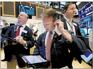  ?? AP/RICHARD DREW ?? Trader Robert Charmak (center) works on the floor of the New York Stock Exchange on Tuesday as U.S. stocks rallied sharply.