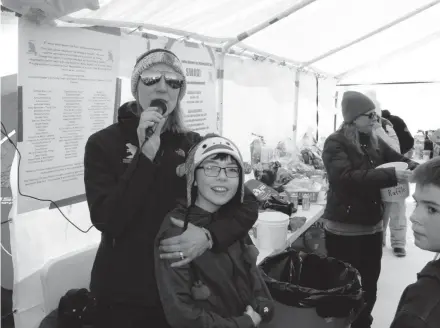  ?? PAUL A. SMITH ?? Michele Baumann of North Prairie hugs Brody Kierzek, 11, of West Bend at the Golden Beaver Ice Fishing Team on Silver Lake in Oconomowoc. The event raised funds to benefit Kierzek and his family. Kierzek suffers from a chronic lung condition called bronchiect­asis and has had 11 surgeries in the last three years.