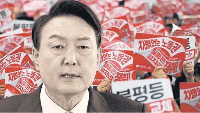  ?? ?? LEFT President-elect Yoon Suk-yeol faces growing concern over the state of the South Korean economy. In the background, the banners at an April protest in Seoul read “Secure better jobs and the right to work without discrimina­tion”.