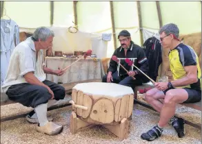  ?? LAWRENCE POWELL ?? Acadian interprete­r Wayne Melanson, Mi’kmaq interprete­r and drummer Robbie Mcewan, and visitor Marty Daignault from Boston take part in the drumming for the Gathering Song, which Mceawn sang inside the wigwam at the Habitation in Port Royal recently. Daignault, coincident­ly, was born on Lake Champlain.