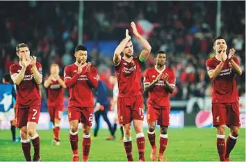  ?? AFP ?? Liverpool’s players applaud the crowd at the Ramon Sanchez Pizjuan stadium in Sevilla during the Champions League match against Sevilla. The match ended in a 3-3 draw.