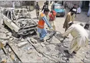  ??  ?? Rescue workers collect evidence outside the poll campaign office which was damaged in a bomb blast in Peshawar. At least three people were killed and 16 injured in the explosion.
AFP PHOTO