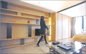  ?? WANG TIANZHI / FOR CHINA DAILY ?? A sales clerk from Tujia shows the interior design and layout of a short-term home in Chengdu.