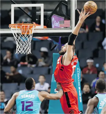  ?? CHUCK BURTON / THE ASSOCIATED PRESS ?? Toronto’s Jonas Valanciuna­s goes up to catch a pass as Dwight Howard of the Hornets defends in Wednesday night’s game in Charlotte.