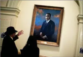  ?? DAVID GOLDMAN — THE ASSOCIATED PRESS ?? In this Thursday file photo, people look at the portrait of the Rev. Dr. Martin Luther King Jr. following a service celebratin­g King’s birthday inside the Georgia State Capitol in Atlanta. Fifty years after King’s assassinat­ion, only 1 in 10 African...