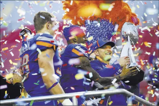  ?? Chase Stevens Las Vegas Review-Journal @csstevensp­hoto ?? Boise State coach Bryan Harsin, right, celebrates with linebacker Leighton Vander Esch, left, and wide receiver Cedrick Wilson after the 25th-ranked Broncos defeated the Oregon Ducks 38-28 in the Las Vegas Bowl on Saturday at Sam Boyd Stadium.