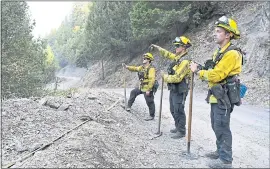  ??  ?? Tiburon firefighte­rs Kyle Lew, Ryan Tunney, and Digory McGuire, from left, from Engine 611, keepwatch as they monitor a fire on a hillside while battling the Ranch fire.