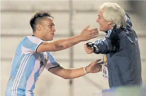  ?? EFE ?? El chico de Racing, autor del empate, va a abrazar al profe Salorio. Lo igualó cuando Argentina jugaba con 10.