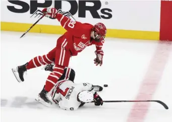  ?? JIM MICHAUD / BOSTON HERALD ?? ‘BAD OFFICIATIN­G’: Boston University’s Matthew Quercia is up-ended by Northeaste­rn’s John Picking during the Beanpot final on Monday night.