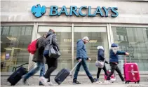  ??  ?? PEDESTRIAN­S walk past a branch of Barclays bank in London.