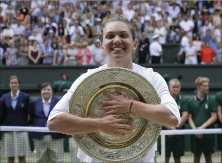  ?? KIRSTY WIGGLESWOR­TH - THE ASSOCIATED PRESS ?? Romania’s Simona Halep poses with the trophy after defeating United States’ Serena Williams during the women’s singles final match on day twelve of the Wimbledon Tennis Championsh­ips in London, Saturday, July 13, 2019.