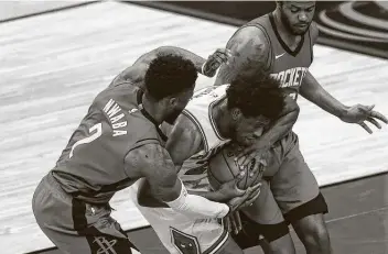  ?? Photos by Yi-Chin Lee / Staff photograph­er ?? The Rockets’ David Nwaba, who led the team with 22 points and nine rebounds off the bench, and Justin Patton, right, battle for the ball with Bulls forward Thaddeus Young during the third quarter on Monday.