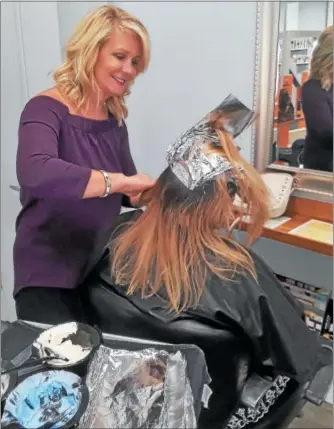  ?? PHOTO COURTESY OF SALON EVOLVE ?? Salon Evolve owner Kim McQuillan colors a client’s hair at her Limerick salon. The foils, as well as left over color are now being recycled by Salon Evolve as part of a salon industry recycling program. Salon Evolve is Green Circle Salon certified, and is recycling its salon waste including hair clippings, left over product, plastic bottles, color tubes and broken styling tools.