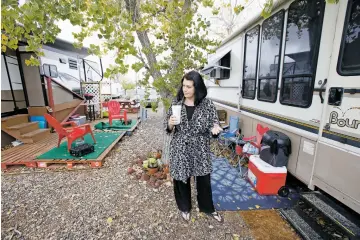  ??  ?? Candace McArthur drinks a cup of coffee Wednesday outside her recreation­al vehicle at Piñon RV Park on Los Pinos Road. McArthur and her husband, who hope to find a permanent residence in Santa Fe or Tesuque, have made room in the RV for two beds and a kitchenett­e with an oven and fridge.