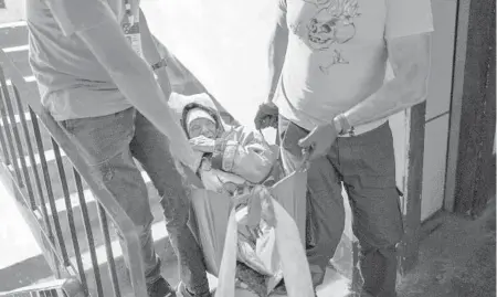  ?? FRANCISCO SECO/AP ?? Volunteers with the Vostok SOS charitable organizati­on evacuate an elderly woman from her home May 26 in Kramatorsk, eastern Ukraine.