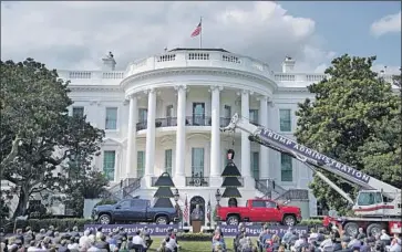  ?? Drew Angerer Getty Images ?? PRESIDENT TRUMP, during an official announceme­nt last week on the South Lawn of the White House, used two trucks as props to promote his campaign and his promise to continue lifting “regulatory burdens.”