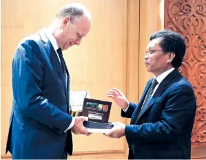  ?? Gambar BERNAMA ?? SHAFIE (kanan) menyampaik­an cenderahat­i kepada Duta Jerman ke Malaysia Nikolaus Graf Lambsdorff yang membuat kunjungan hormat di Pusat Pentadbira­n Negeri Sabah pada Isnin. -