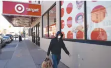  ?? AP FILE PHOTO/MARK LENNIHAN ?? A customer wearing a mask carries his purchases as he leaves a Target during the coronaviru­s pandemic in the Brooklyn borough of New York.