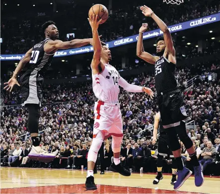  ??  ?? Sacramento Kings defenders Harry Giles, left, and Marvin Bagley III attempt to stop Raptors guard Danny Green’s drive to the net during Tuesday night’s game in Toronto. — THE CANADIAN PRESS