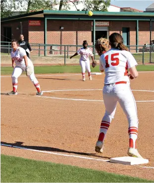  ?? Staff photo by Josh Richert ?? ■ Texas High first baseman Kaitlyn Cross awaits the throw from Lady Tiger third baseman Korie Hamilton, center, to end the third inning against Sulphur Springs, which stranded two in the inning, during the District 16-5A softball game Monday at Lady...