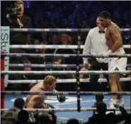  ?? MATT DUNHAM - THE ASSOCIATED PRESS ?? Russian boxer Alexander Povetkin goes down after taking a punch from British boxer Anthony Joshua, right, in their WBA, IBF, WBO and IBO heavyweigh­t titles fight at Wembley Stadium in London, Saturday.