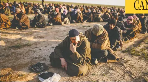  ?? BULENT KILIC/AFP/GETTY IMAGES ?? Men suspected of being ISIL fighters wait to be searched by members of the Syrian Democratic Forces in Syria’s Deir ez-zor province in February.