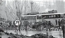  ?? UMER ASIF/AP ?? Indian paramilita­ry soldiers survey bus wreckage after an attack Thursday in Kashmir.