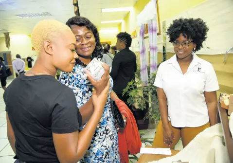  ?? ALLEN/PHOTOGRAPH­ER IAN ?? Jo-Ann Morris (right), owner of Rachel Lane’s Accessorie­s, looks on as Natalee Gordon (left) and Amanda McKenzie admire her scented candles during the Jamaica Business Developmen­t Corporatio­n’s Design Fusion 2019 closing ceremony in Kingston last Wednesday.