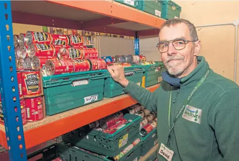  ?? ?? TAKING STOCK: Foodbank volunteer David Grieve looks over the donations ready to be distribute­d across Shetland.