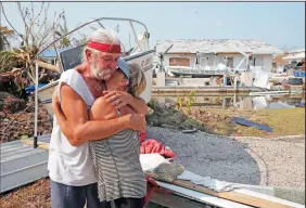  ?? CHARLES TRAINOR JR./MIAMI HERALD ?? David and Dee Thorne hug near the remains of their home following Hurricane Irma on Big Pine Key in the Florida Keys, on Sept. 20. They are living in an RV on the lot as they begin to repair the house.