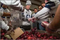  ?? Staff photo by Joshua Boucher ?? ABOVE TOP RIGHT: Southweste­rn Oklahoma State football players pack apples into bags so they can be delivered to rural communitie­s Friday at Harvest Texarkana, one of the organizati­ons the United Way supports.