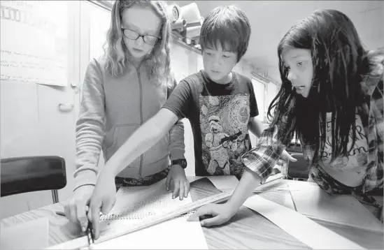  ?? Francine Orr Los Angeles Times ?? EAGLE ROCK Elementary students Beatrice Wild, 10, left, Kiyan Vahedi, 10, and Amy Carrola, 10, right, work together during their fifth-grade class.